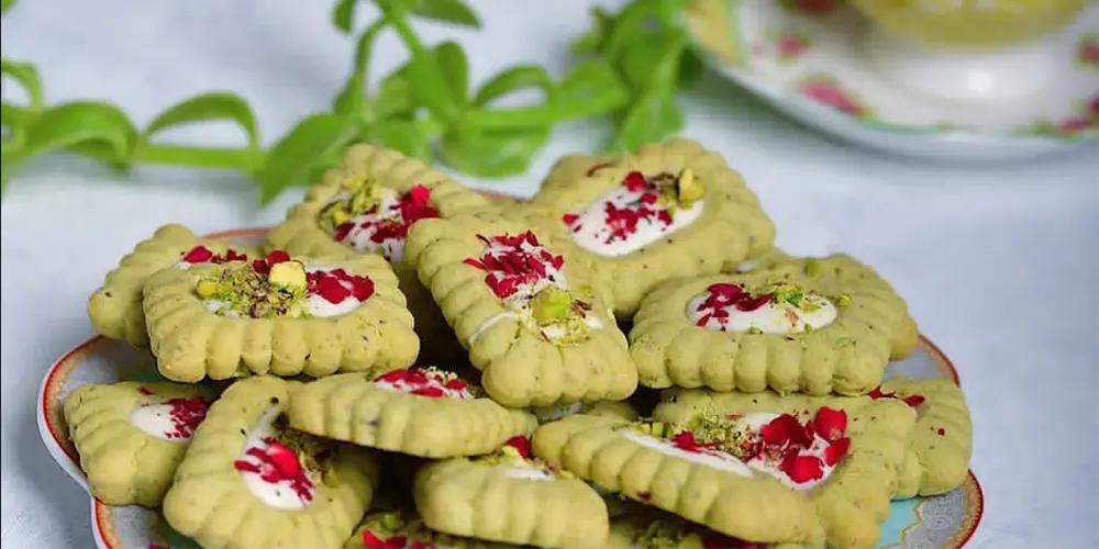 شیرینی عید خانگی بیسکویتی پسته‌ ای کرم‌ دار 